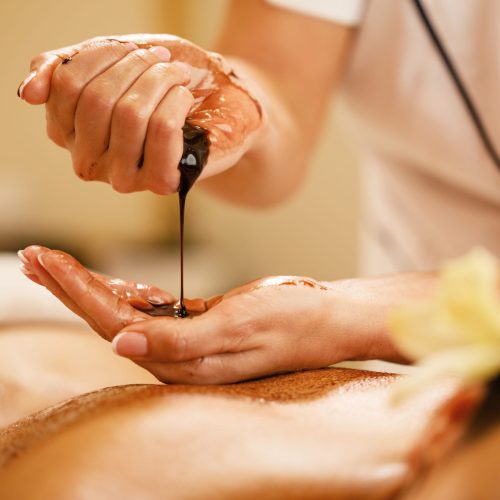 closeup-massage-therapist-pouring-hot-chocolate-her-hands-before-spa-treatment (1)