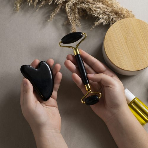 top-view-hands-holding-face-roller-gua-sha